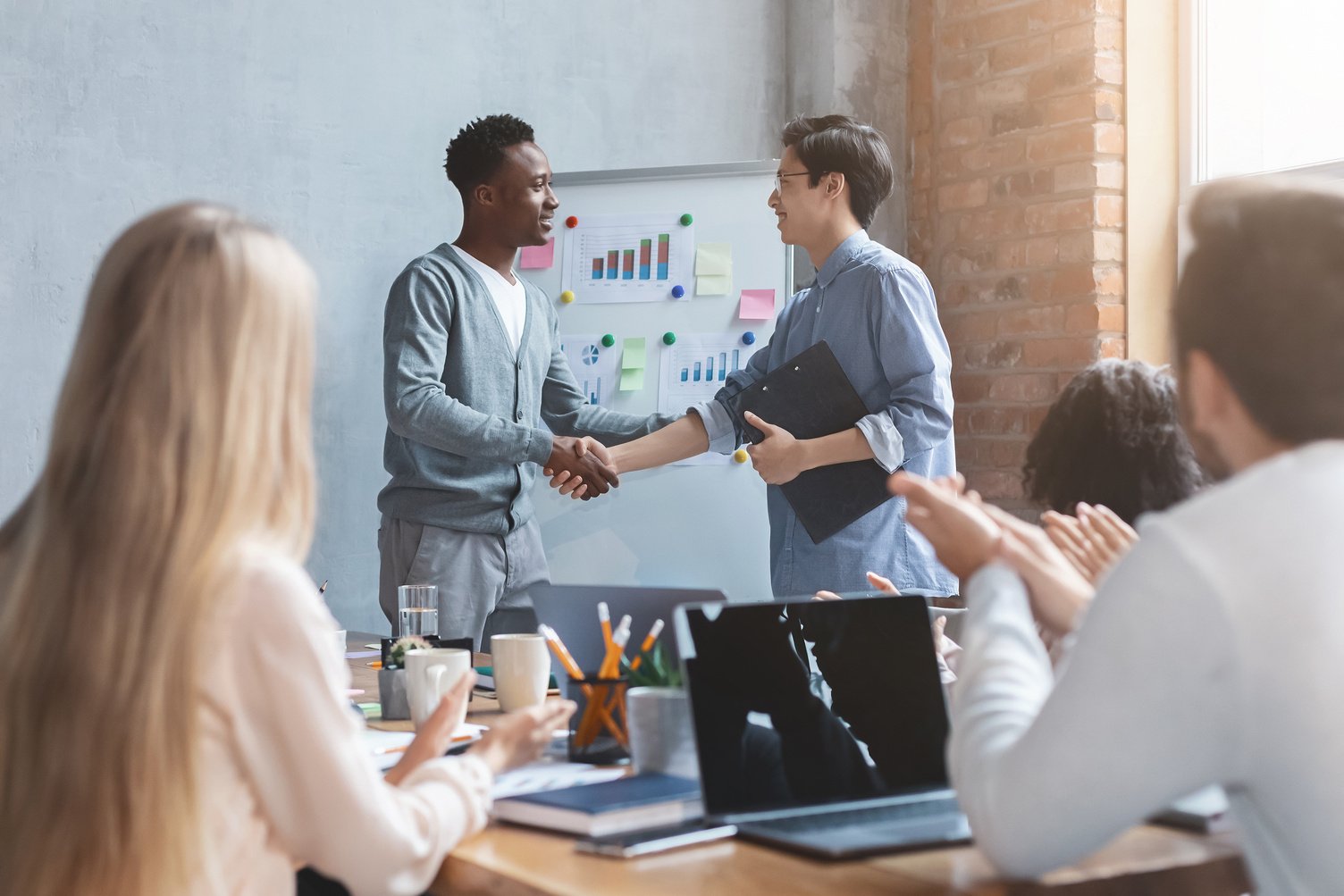 Young black manager shaking hand to asian employee